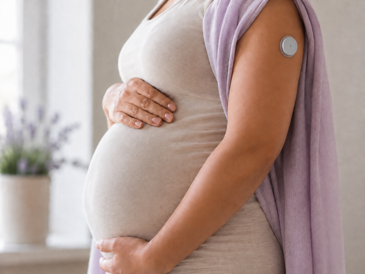 Schwangere Frau mit Diabetes-Sensor am Arm